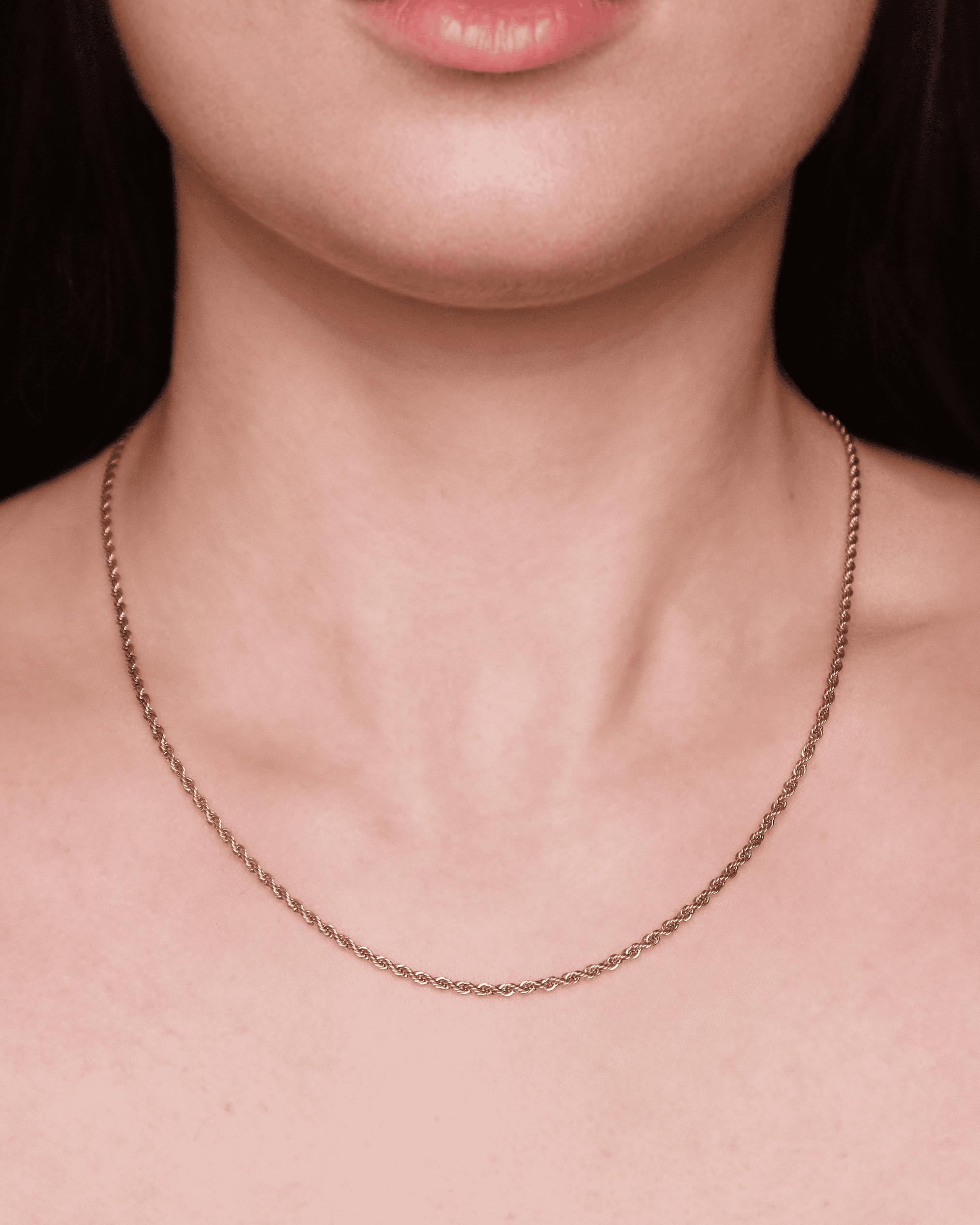 Collana finemente intrecciata indossata su pelle chiara.