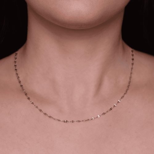 Collana elegante sotto il collo di una persona.