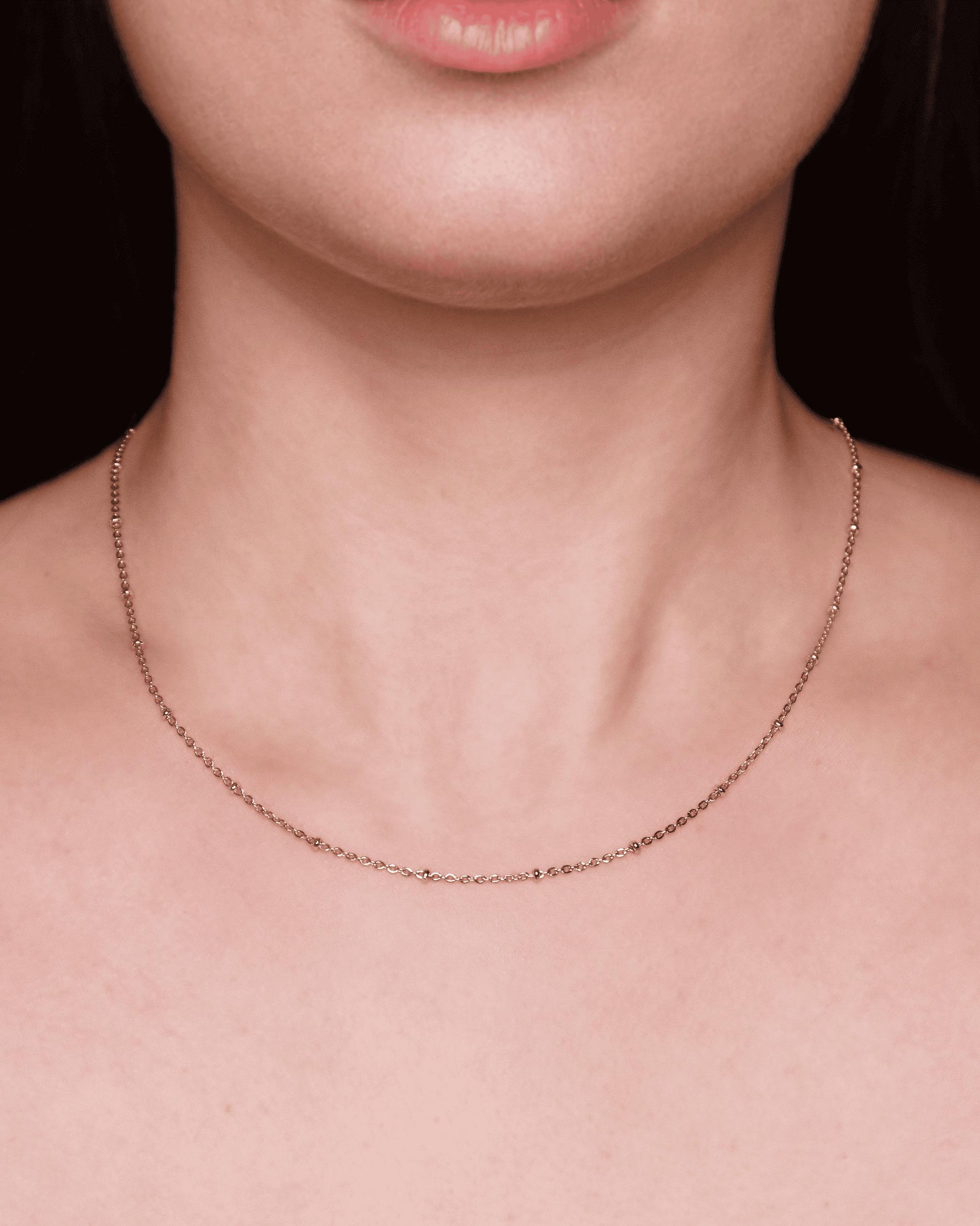 Collana sottile indossata su collo femminile.