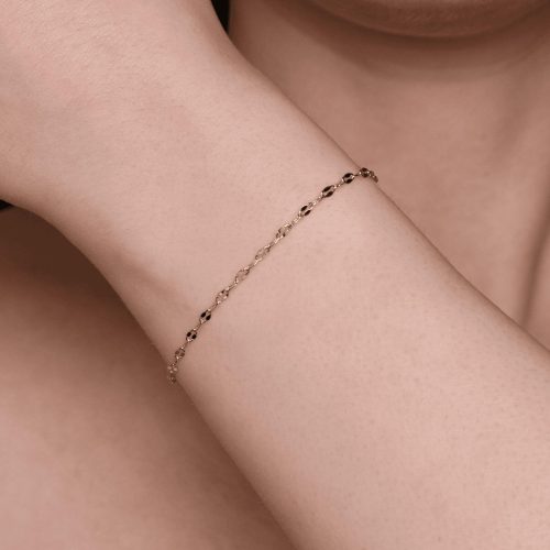 Bracciale elegante in oro con perline nere.