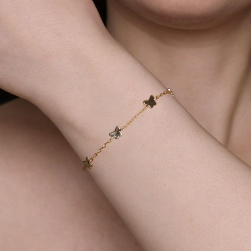 Bracciale dorato con ciondoli a farfalla al polso